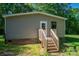Back entrance with wooden stairs and a brick foundation, surrounded by lush greenery at 4920 Morrison Houser Trl # 2, Lincolnton, NC 28092