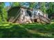 Exterior view showing the side of the home, brick foundation, green lawn, and steps to a small back deck at 4920 Morrison Houser Trl # 2, Lincolnton, NC 28092