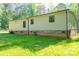 View of the back exterior of the home, surrounded by a chainlink fence and lush greenery at 4920 Morrison Houser Trl # 2, Lincolnton, NC 28092