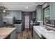 Well-lit kitchen featuring stainless steel appliances, a pantry, green cabinets and a white farmhouse sink at 4920 Morrison Houser Trl # 2, Lincolnton, NC 28092