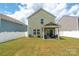 Spacious backyard featuring a covered patio, lush green lawn, and a white vinyl privacy fence at 507 Newfound Hollow Dr, Charlotte, NC 28214
