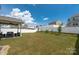Large, private backyard with a well-manicured lawn, white fence, and covered patio at 507 Newfound Hollow Dr, Charlotte, NC 28214