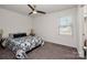 Bright bedroom featuring a ceiling fan, neutral walls, plush carpet, and a large window at 507 Newfound Hollow Dr, Charlotte, NC 28214