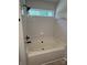 Bathroom featuring a bathtub with black hardware, bright white tile, and window at 5637 Hedgecrest Pl, Charlotte, NC 28269