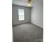 A simple bedroom with gray walls, carpet, a ceiling fan, and a window at 5637 Hedgecrest Pl, Charlotte, NC 28269