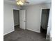 A bedroom with gray walls, carpet, and two doors at 5637 Hedgecrest Pl, Charlotte, NC 28269