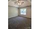 Spacious bedroom with tray ceiling, ceiling fan and natural light from the window at 5637 Hedgecrest Pl, Charlotte, NC 28269