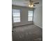 A carpeted bedroom with gray walls, two windows, and a ceiling fan at 5637 Hedgecrest Pl, Charlotte, NC 28269