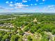 An aerial view highlighting the property's location and surrounding neighborhood with lush trees and a road nearby at 6012 Tuckaseegee Rd, Charlotte, NC 28208