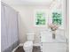 Bathroom featuring a shower with curtain, toilet, vanity with marble countertop, and window at 6012 Tuckaseegee Rd, Charlotte, NC 28208