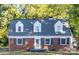 Charming brick home with dormer windows, black shutters, and inviting front door at 6012 Tuckaseegee Rd, Charlotte, NC 28208