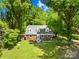 Charming brick home with well-maintained lawn, mature trees, and inviting front porch seating at 6012 Tuckaseegee Rd, Charlotte, NC 28208