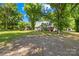 A brick house, trees, and grass yard creating a relaxed setting at 6012 Tuckaseegee Rd, Charlotte, NC 28208