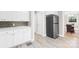 Kitchen featuring white cabinets, stainless steel refrigerator, and adjacent dining area at 6012 Tuckaseegee Rd, Charlotte, NC 28208