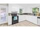 Bright kitchen featuring white cabinetry, stainless steel appliances, and modern backsplash at 6012 Tuckaseegee Rd, Charlotte, NC 28208