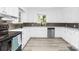 Well-lit kitchen featuring white cabinets, modern appliances, and decorative backsplash at 6012 Tuckaseegee Rd, Charlotte, NC 28208