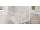 Staircase with white railing and hardwood floors leading to the upper level of the home at 6012 Tuckaseegee Rd, Charlotte, NC 28208