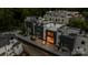Wide aerial of modern townhouses with rooftop decks, dark garage doors, and balconies against lush greenery at 614 Queens Rd, Charlotte, NC 28207