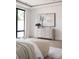 Well-lit bedroom showcasing a modern dresser with art piece above, complemented by large windows and hardwood floors at 614 Queens Rd, Charlotte, NC 28207