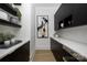 A butler's pantry offers white countertops with dark cabinets, shelving, and stainless steel appliances at 614 Queens Rd, Charlotte, NC 28207