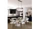 Elegant dining room features modern light fixture, striking art, and chairs set at a glass table at 614 Queens Rd, Charlotte, NC 28207