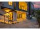 A well-lit modern townhouse entrance with a black framed door, glass garage door, and concrete walkway at 614 Queens Rd, Charlotte, NC 28207