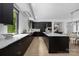 Modern kitchen features a large island with white countertops and dark cabinets and stainless steel appliances at 614 Queens Rd, Charlotte, NC 28207