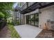 Covered patio with large sliding glass doors surrounded by manicured landscaping and brick accents at 614 Queens Rd, Charlotte, NC 28207
