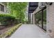 An outdoor patio area that's adjacent to mature landscaping and large glass doors at 614 Queens Rd, Charlotte, NC 28207