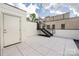 Modern rooftop deck featuring gray tile, a white door, and exterior stairs with metal railings at 614 Queens Rd, Charlotte, NC 28207