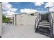 Modern rooftop deck featuring gray tile, white privacy walls, and black metal stairs at 614 Queens Rd, Charlotte, NC 28207