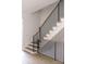 Modern staircase featuring wooden steps with black metal railings and white walls at 614 Queens Rd, Charlotte, NC 28207