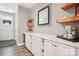 A modern bar area with white cabinets, quartz countertops, and floating wood shelves offers a sleek design at 6295 Ashton Park Dr, Denver, NC 28037