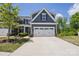 Charming home with a two-car garage, a manicured lawn and blue siding at 6295 Ashton Park Dr, Denver, NC 28037