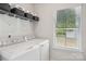 Well-lit laundry room featuring new appliances, a window, and extra storage with shelving, perfect for organizing laundry at 6295 Ashton Park Dr, Denver, NC 28037