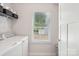 Well-lit laundry room featuring new appliances, a window, and extra storage with shelving, perfect for organizing laundry at 6295 Ashton Park Dr, Denver, NC 28037