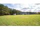 A large green backyard features the home, white wood deck and two storage sheds at 6300 Bill Sain Rd, Vale, NC 28168