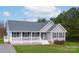 Well-maintained home with a welcoming front porch, gray siding, black shutters, and mature trees at 6300 Bill Sain Rd, Vale, NC 28168