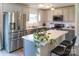 Well-lit kitchen with stainless steel appliances, grey cabinets, and an island with barstool seating at 6300 Bill Sain Rd, Vale, NC 28168