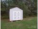 Light grey outbuilding featuring a gable roof and white double doors, surrounded by mature trees at 6300 Bill Sain Rd, Vale, NC 28168