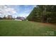 A view of the beautiful, grassy, spacious front yard with trees surrounding the property at 6300 Bill Sain Rd, Vale, NC 28168