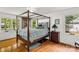Bright main bedroom featuring a four-poster bed, hardwood floors, and natural light at 709 Weldon Ln, Salisbury, NC 28146