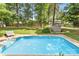 Backyard view of a private in-ground pool, lush landscaping, and storage shed at 709 Weldon Ln, Salisbury, NC 28146