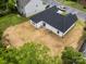 An aerial view shows a spacious backyard and a newly constructed home with a dark roof at 722 English St, Monroe, NC 28110