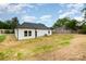 Back of the home with newly planted lawn, featuring white siding and a dark roof at 722 English St, Monroe, NC 28110