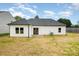 A view of the house's back exterior with a dark roof and white siding and a small patio at 722 English St, Monroe, NC 28110