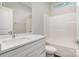 Bright bathroom features a combination tub and shower unit, vanity with marble countertop, and window at 722 English St, Monroe, NC 28110