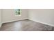 Bright empty bedroom with wood-look flooring, window for natural light, and electrical outlets at 722 English St, Monroe, NC 28110