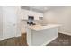 Bright kitchen with white cabinets, stainless appliances, a central island, and hardwood flooring at 722 English St, Monroe, NC 28110