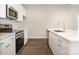 Modern kitchen featuring stainless steel appliances, white cabinets, and island with sink at 722 English St, Monroe, NC 28110